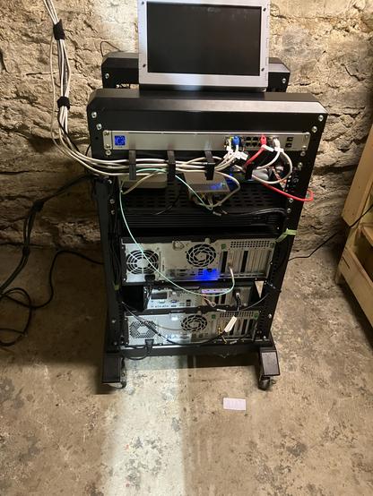 A rack with theree workstations, a rack-mount Pi, two switches and a bunch of wiring