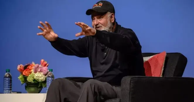 Rob Reiner on stage at a convention.
