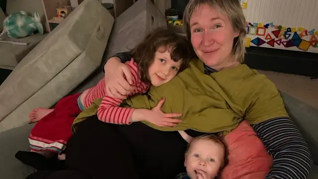 Naja smiling with her two children, family photo before illness worsened.