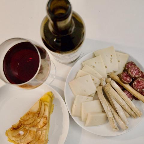 Local snacks: red wine, apple cake, cheese, and cured sausage.