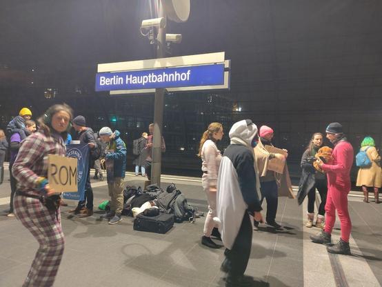 Aktivist:innen tanzen auf einem Gleis am Berliner Hauptbahnhof
