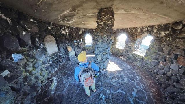 One of a series of photos showing a person hiking around a lava rock field in the Willamette National Forest of central Oregon, often observing distant mountains on the horizon, all under clear blue skies.