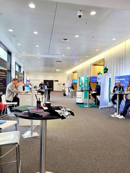 mehrere aussteller an hochstischen im gang