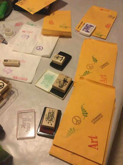 vertical image of stamped manilla envelopes and rubber stamps and rubber stamp pads and dirty napkins