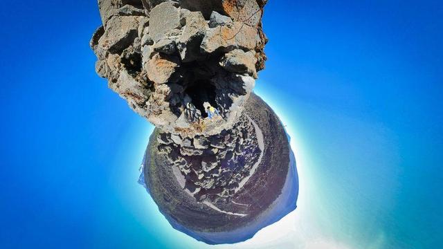 One of a series of photos showing a person hiking around a lava rock field in the Willamette National Forest of central Oregon, often observing distant mountains on the horizon, all under clear blue skies.