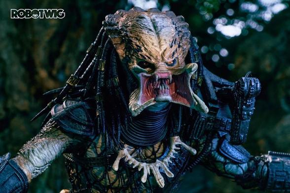 Predator stands arms out open mouthed I aggressive stance. Jungle background