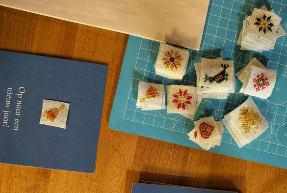 Stapeltjes van de geborduurde kerstfiguurtjes/-icoontjes, per figuurtje een stapeltje.