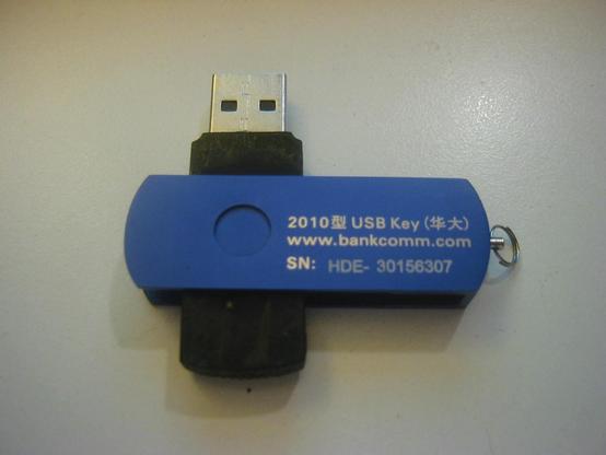 The reverse of a USB smart card, "2010 USB key", a web domain of bankcomm[DOT]com and a "SN" serial number embossed on the USB