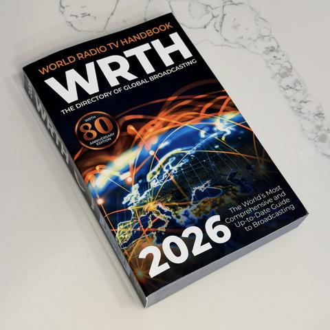 A book titled "WRTH 2026" with a world map and neon light design on the cover, lying on a white surface.