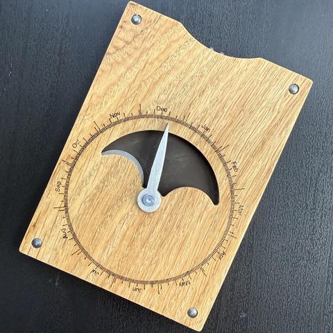 Mechanical calculator „Meton“, made of wood and steel, showing the moon phase for December 21st, 2025.