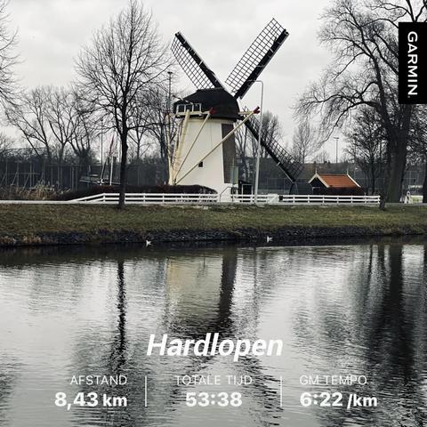 A windmill and some trees reflected in the water. Displayed on top of the photo is the following: distance 8,43km, total time 53:38 and tempo 6:22 /km.