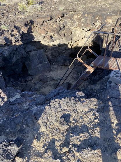 A metal ladder leads down into the boring lava tubes