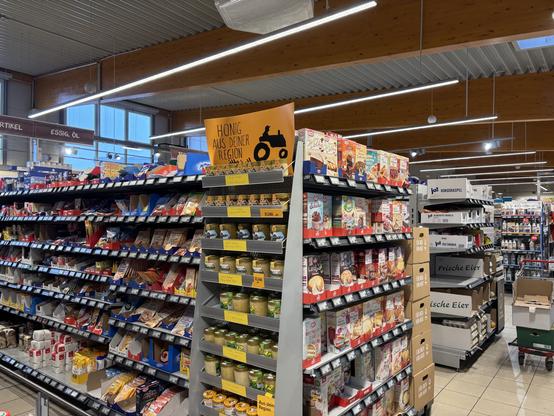 In einem Rewe Nahkauf: Regale mit Lebensmitteln