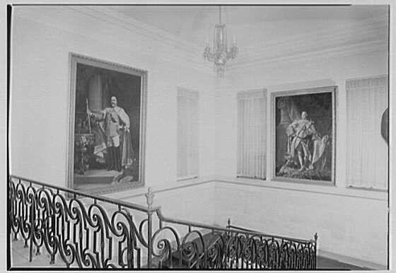 The image depicts an interior scene of a room with historical paintings displayed on the walls, which include portraits possibly from earlier centuries. The architecture suggests it could be within a historic building or institution. There is also a chandelier visible in the upper portion and decorative ironwork along what seems to be a staircase railing below.

1945 Feb 16" indicates that this photograph was taken on February 16, 1945. Gottscho-Schleisner, Inc., which appears alongside "British Embassy," implies that it could have been commissioned by or for the British government during World War II era in Washington D.C.

Given these details and context clues within the image's description, one might infer this photograph was likely taken to document historical interiors or spaces of significance at a time when such documentation would be relevant.