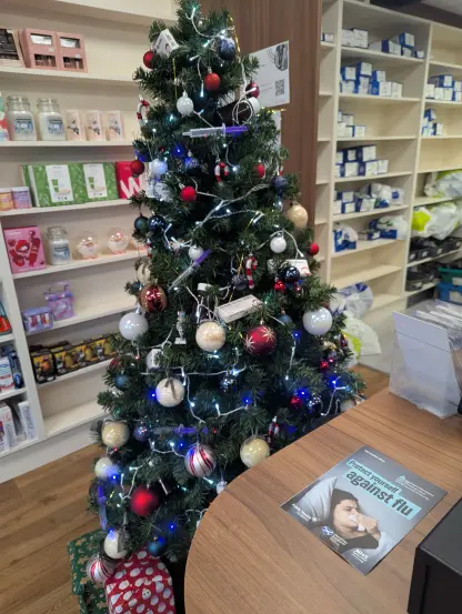 An image of a Christmas tree decorated with the usual baubles but also syringes and medicine tablet packages