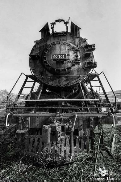 A black and white close-up of a rusty steam train. The train's number "643" is clearly visible