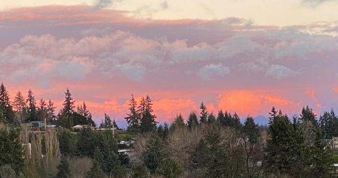 Closeup on the most intense section of the previous photo, cropped in to the cloud bank and a section of the most intense colours, highlighting the reflected lights at the mountains and lowest, most distant clouds.