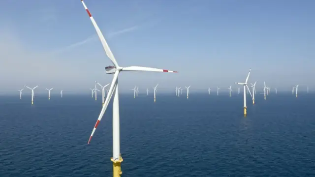 The debate around electric vehicles, windmills, Greenland, Venezuela, oil, and tariffs often appears fragmented, as if each issue exists in its own policy silo. That illusion serves power well. When examined together, these issues reveal a coherent and troubling strategy rooted in protecting entrenched corporate interests—particularly fossil fuels—through coercion, misinformation, and state intervention. The common thread between EVs, … Tariffs on Chinese-made electric vehicles offer the first clue. Classical capitalism argues for efficiency: if another country produces a superior product at lower cost, markets should reward that efficiency. Instead, punitive tariffs block affordable EVs while U.S. automakers scale back production. This is not market correction; it is market distortion. The private sector failed to invest aggressively in EVs when it had the chance, and now the state shields that failure rather than confronting it. That choice delays climate progress and leaves working families paying more for fewer options. The same logic explains the hostility toward wind energy. Offshore wind projects—many led by Danish firms like Ørsted—represent large-scale threats to oil’s dominance. Claims that turbines threaten national security collapse under basic physics and radar science. Modern militaries already distinguish complex signal environments. What truly alarms fossil interests is that wind power reduces dependence on oil, shrinking profits and geopolitical leverage. Tha