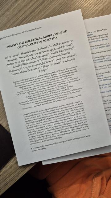 A photo of the article "Against the Uncritical Adoption of 'AI' Technologies in Academia by Olivia Guest et. al. printed out.