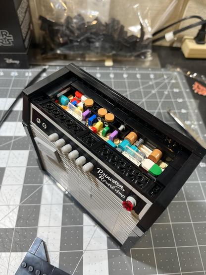 Detail view of a Lego model Fender Princeton Reverb amp with the top panel removed to show the circuit  board that consists of various colored Lego bricks.