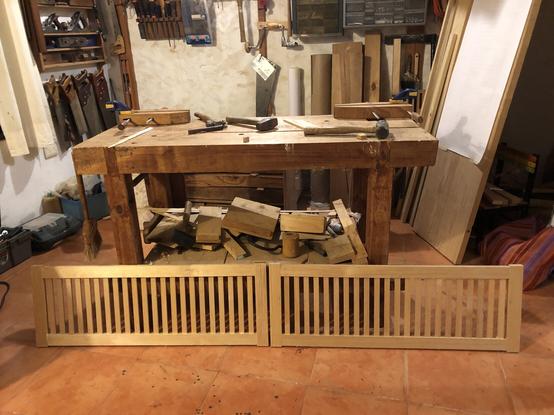 Las dos puertas en el piso del taller, descansando sobre el banco de trabajo.