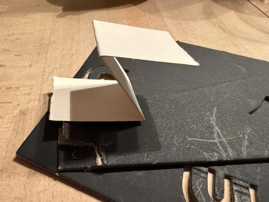 Ein Streifen Pappe liegt auf der Rückwand als „Z“ gefaltet