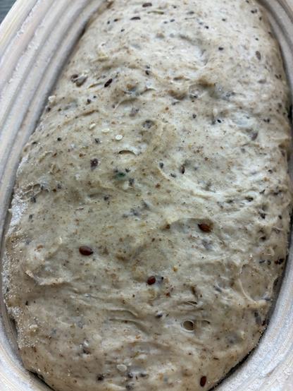 Sourdough in a batard banneton showing seeds and sage.