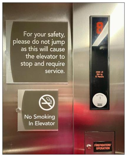 Interior of elevator at a hotel.   Various signs such as 

2500 LB
1134 kg
15 Persons

Firefighters Operation

No Smoking in Elevator

For your safety, please do not jump as this will cause the elevator to stop and require service.