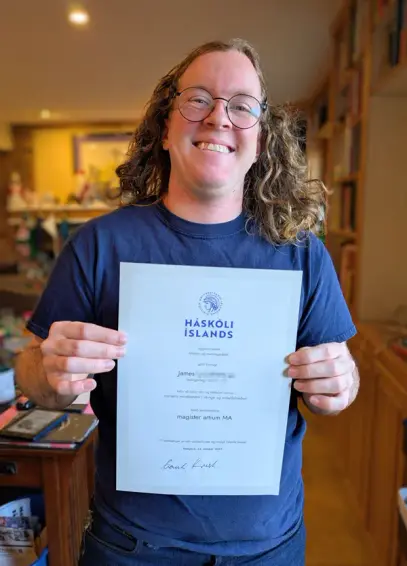 James holding his MA diploma from the U. of Iceland.