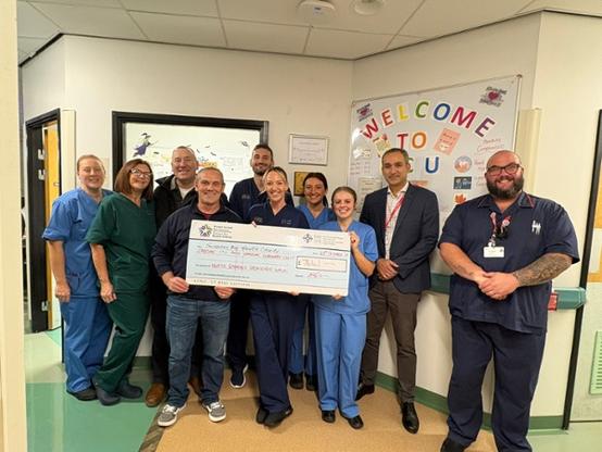 Llanddarog Young Farmers’ Club members with Morriston Hospital cardiac staff holding a large cheque for £3,500.