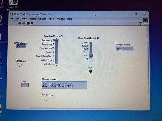 Poor photo of the laptop screen showing the LabVIEW virtual instrument control panel controlling the Fluke counter via GPIB. The display shows mode control, time base, cycle LED, and output measurement of 20.123460 MHz. It works!