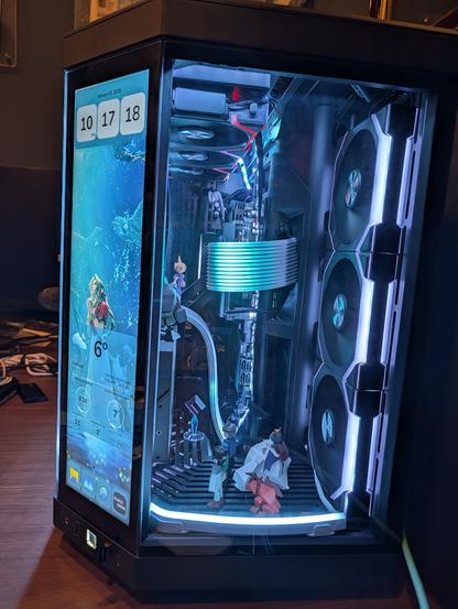 Side view of the PC showing figurines of cait sith yuffie red xiii, along with city of the ancients themed RGB lighting