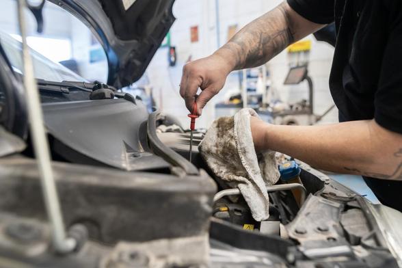 Un mecánico comprobando el aceite de un coche en un taller. (Getty Images)