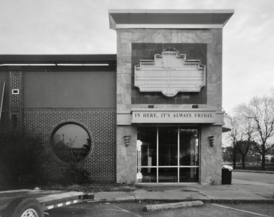 Derelict Friday’s restaurant. Signs have fallen off and there is a flatbed trailer parked out front.