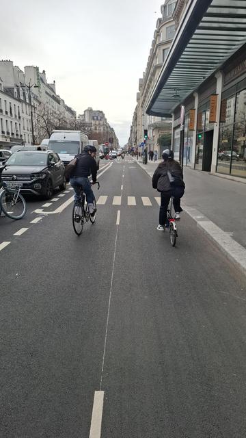 La nouvelle piste cyclable rue Réaumur. Deux  cyclistes circulant de front. Il n'y a pas de potelet au travers de la piste