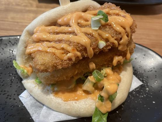 Delicious crumbed tofu pieces with suce in a bao bun