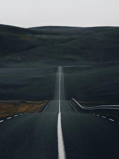 Optimismus in Schwellenzeiten ist die Basis einer besseren Zukunft, in der Demokratie gegen Faschismus gewinnen wird. Durchhalten, Verbindlichkeit und klare Kante.
Bildbeschreibung (Deutsch)
Das Bild zeigt eine lange, gerade Straße, die sich durch eine dunkle, weite Landschaft zieht und am Horizont im Unbekannten verschwindet. Die klare Mittellinie führt den Blick nach vorn und symbolisiert Orientierung, Richtung und innere Haltung. Die umliegende Landschaft wirkt rau, still und entleert
- ein Sinnbild für Schwellenzeiten, in denen alte Sicherheiten verschwinden und neue Wege noch nicht sichtbar sind.
Die Straße steht für den demokratischen Prozess selbst: kein Sprung, kein Abkürzen, sondern konsequentes Voranschreiten. Optimismus zeigt sich hier nicht als Naivität, sondern als bewusste Entscheidung, Schritt für Schritt handlungsfahig zu bleiben. Durchhalten, Verbindlichkeit und klare Kante werden zu stabilisierenden Kräften, die verhindern, dass Angst, Autoritarismus und Faschismus das Feld übernehmen. Zukunft entsteht nicht durch Hast, sondern durch Richtungstreue.🖖