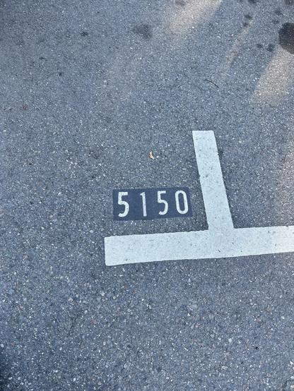Lines marking the edges of 2 parking spots on the asphalt. One is labelled 5150