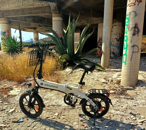a photo of my folding ebike in front of an abandoned building and a maguey plant.