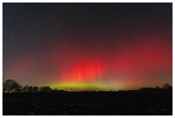Polarlichter (rot/grün) im Nachthimmel.