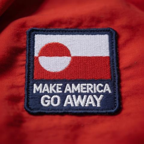 A close-up of an embroidered patch featuring a design with red and white colors and the text "MAKE AMERICA GO AWAY" on a red fabric background.