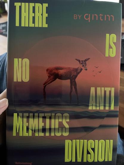 Das Cover des Buchs. Dort ist ein vieräugiges Reh zu sehen, das von einem Kreis eingerahmt wird. Der Titel des Buchs ist in großen gelben Buchstaben abwechselnd links- und rechtsbündig über das Cover verteilt.