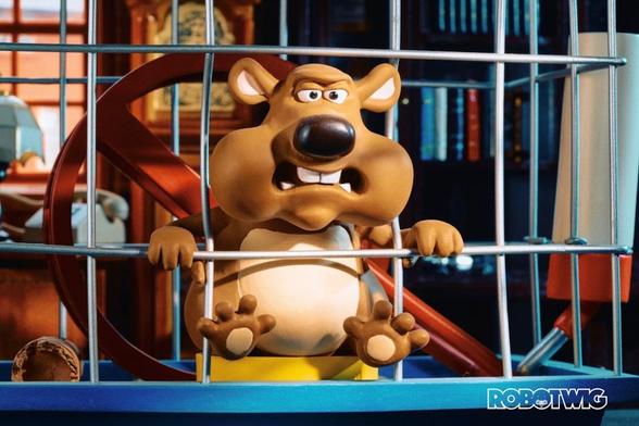 Fluffy the Hamster pokes his head through his cage to discuss things with an interviewer. Living room setting