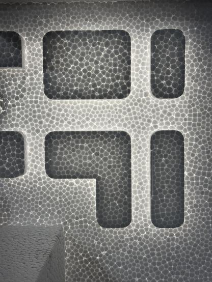 More of the polystyrene with thick and thin areas and light shining through it creating light and dark patterns