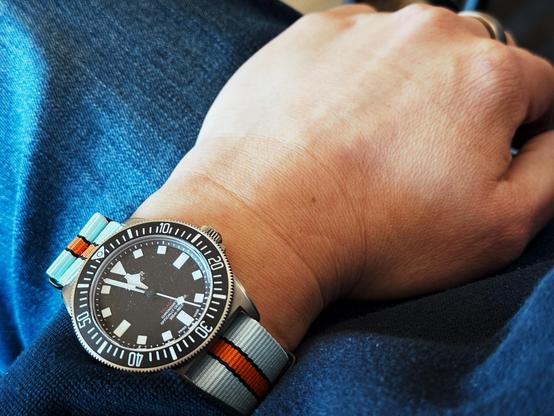 A black dual and bezel Tudor Pelagos FXD on a gulf colors nato strap