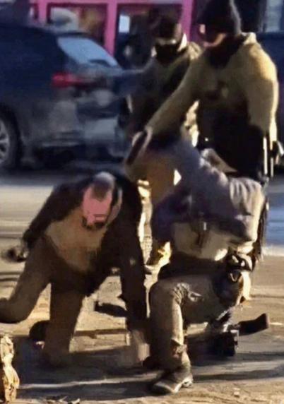Bildbeschreibung (Deutsch)
Das Bild zeigt eine gewaltsame Szene im öffentlichen Raum: Mehrere uniformierte, bewaffnete Einsatzkräfte fixieren zwei unbewaffnete Personen am Boden. Die Betroffenen befinden sich in kniender bzw. gestützter Haltung, sichtbar unter Zwang und ohne erkennbare Möglichkeit zur Gegenwehr.
Körperhaltungen, Grifftechniken und die räumliche Überlegenheit der Einsatzkräfte lassen auf eine vollständige Kontrolle der Situation schließen.
Im Kontext der Interpretation steht das Bild symbolisch für die Entmenschlichung staatlicher Gewalt, wenn Menschen nicht mehr als Träger von Würde, sondern als zu kontrollierende Objekte behandelt werden. Es verweist auf historische und gegenwärtige Muster autoritärer und faschistischer Systeme, in denen Gewalt normalisiert und moralische Hemmschwellen systematisch abgebaut werden. Das Bild fungiert damit weniger als Einzelfall, sondern als Warnsymbol für den Zusammenbruch humanistischer Prinzipien.🖖