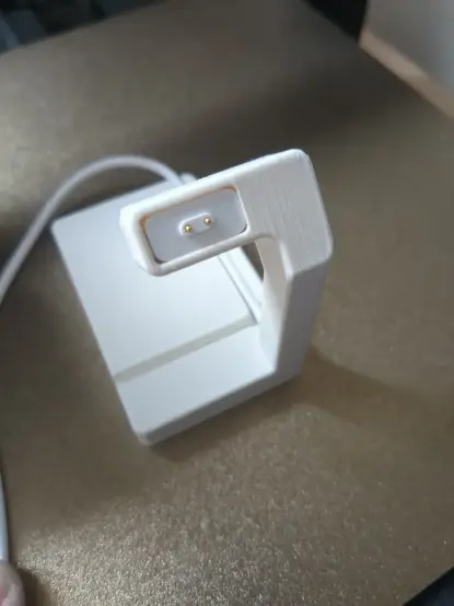 Photograph of the 3D printed stand from above, highlighting the charge connector inserted inside.