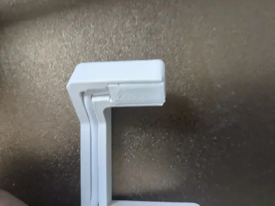 Photograph of the 3D printed stand showing how the charge connector is kept in place by a 3D printed sheet that slides from one side.