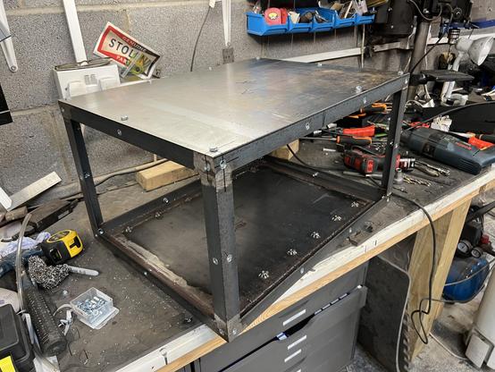 3/4 view looking at the battery box frame with the lid in place and bolted down.