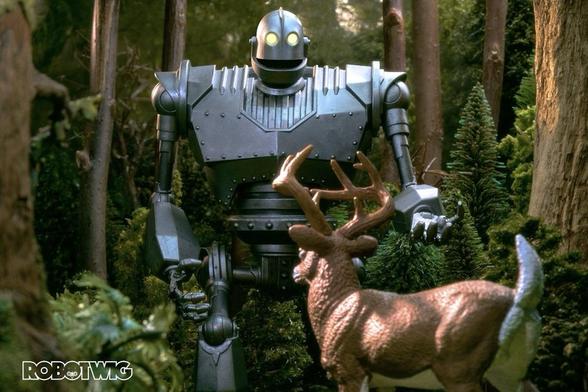 The Iron Giant sees a deer in the forest he reaches his hand out as he walks toward it.
